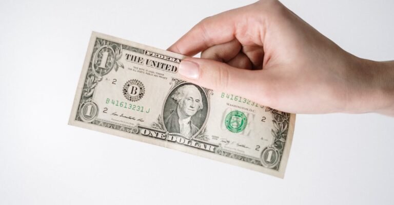 Close-up of a Caucasian hand holding a US one dollar bill against a white background. What is Dollar-Cost Averaging. Dollar-Cost Averaging is the practice of investing a fixed amount of money into a particular investment at regular intervals—regardless of the share price.